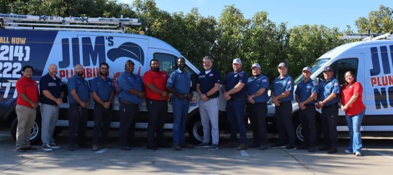 Jim's Plumbing Now team standing in front of branded vans